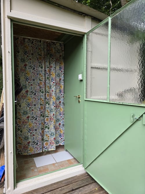 Entrée de cottage verdoyant aux voilages fleuris du camping Domaine Trianon, Villandry