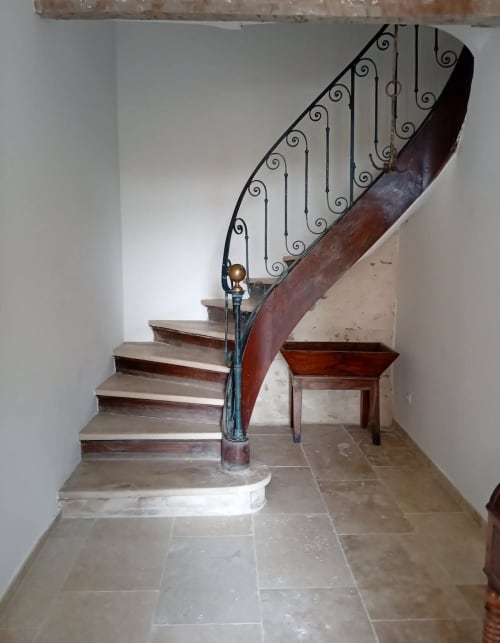 Escalier en spirale aux ornements en fer forgé de la maison d'hôtes Chez Laure & Marc à Plaissan