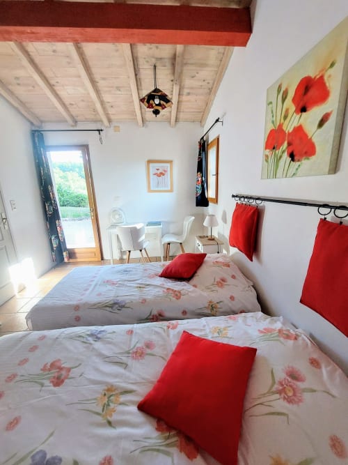 Poppy room at Les Gites de Campardon B&B in Monties with twin beds, floral bedding, and garden view