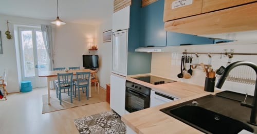 Cuisine et salle à manger modernes de l'appartement Mer et Maisons, La Trinité sur Mer, avec accents bleu-vert et balcon vue mer