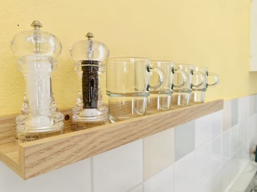 Moulins à sel et poivre avec des tasses en verre sur une étagère en bois à l'hôtel Maisons En Or à Sinnamary, Guyana