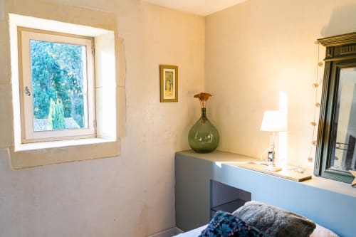 Chambre lumineuse au Mas F à Saint Rémy de Provence avec vue sur le jardin, bureau équipé d'une lampe et vase vert