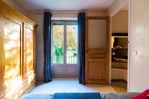 Chambre lumineuse au Mas F B&B à Saint Rémy de Provence avec vue sur le jardin par portes-fenêtres et rideaux bleus