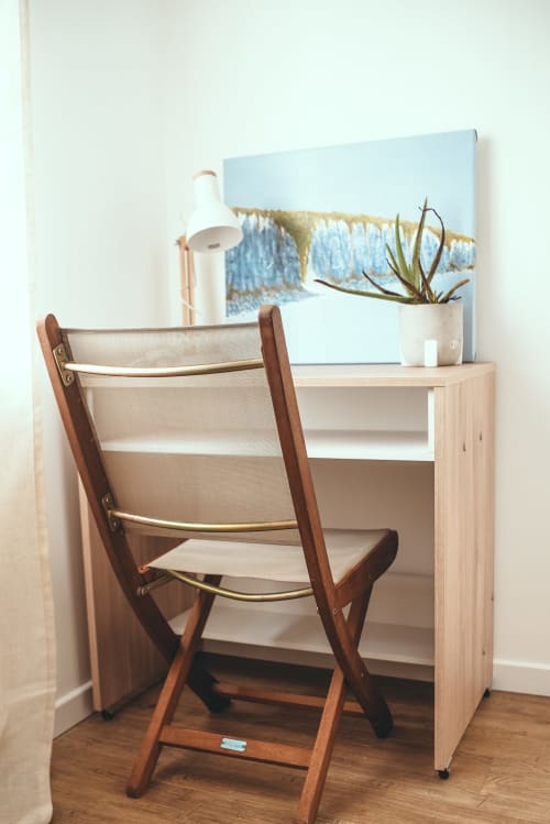 Bureau en bois clair avec fauteuil cuir, lampe de bureau blanche et plante verte dans le cottage Les Tropiques à ART DE VOYAGER, Étretat