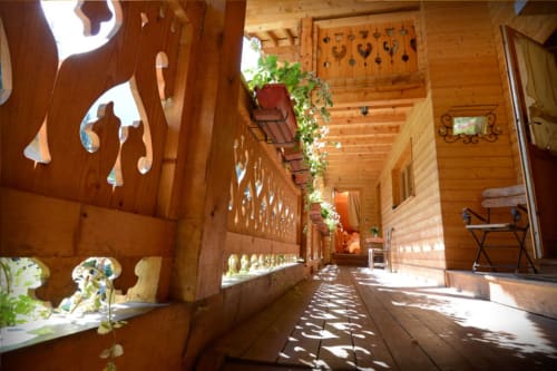 Couloir en balcon en bois à l'Auberge Nemoz avec panneaux décoratifs, plantes suspendues et vues sur les montagnes au Haut-Bréda, France