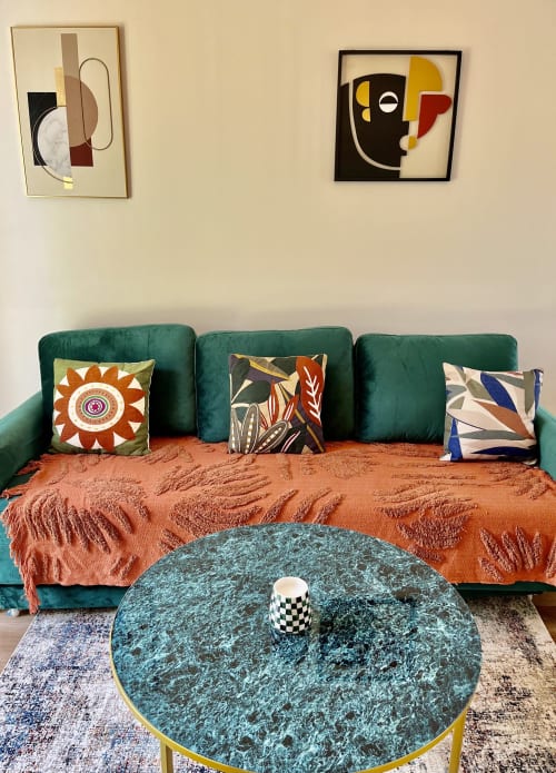 Salon vibrant du cottage d'Étretat avec canapé turquoise, plaid orange, coussins motifs et art abstrait mural