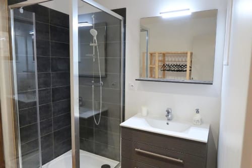 Salle de bain moderne de l'appartement La Suite aux Gites Saint Valery En Caux avec douche à l'italienne, lavabo et miroir