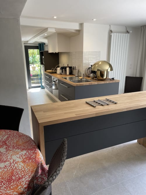 Cuisine et salle à manger contemporaines du gîte Les Pratges à Figeac, avec plans de travail en bois et mobilier noir