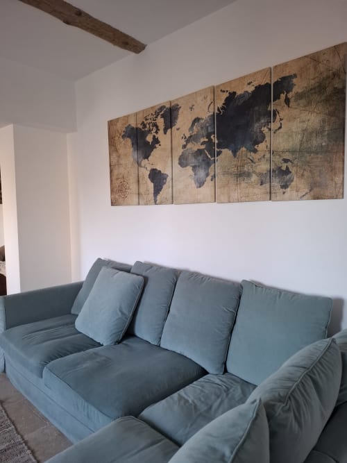 Canapé bleu rembourré avec coussins dans le séjour du gîte familial Chez Laure & Marc à Plaissan, avec carte du monde vintage