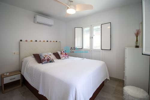 Suite moderna en Casa lirio blanco de setenil de las bodegas con cama queen, aire acondicionado, ventilador de techo y puertas al balcón