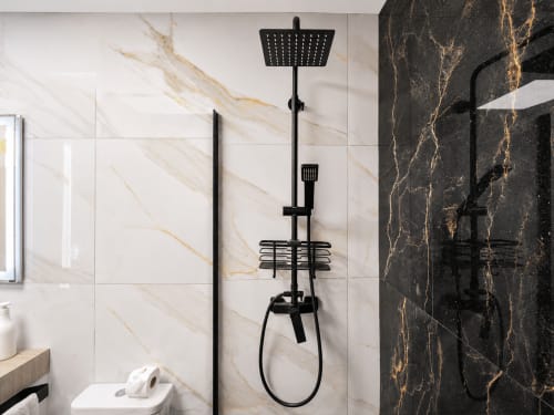 Sistema de ducha de lluvia moderno en negro con paredes de mármol en el baño de Apartamentos El Calón Playa, Cuevas del Almanzora
