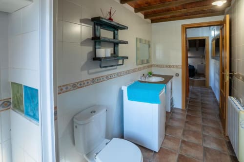 Baño moderno en Front Beach Apartments, Montgat con azulejos blancos, lavamanos, inodoro y techo con vigas de madera