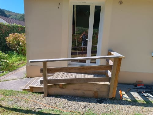 Terrasse en bois en construction au cottage Les Tropiques à Étretat, vue sur le jardin et portes vitrées modernes