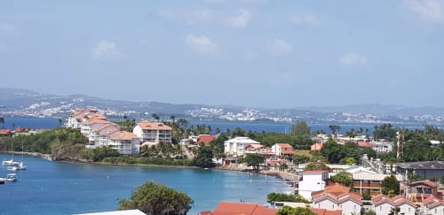 Vue waterfront des appartements Kay Betty aux Trois-Îlets, Martinique avec vue sur mer, végétation tropicale et îles avoisinantes