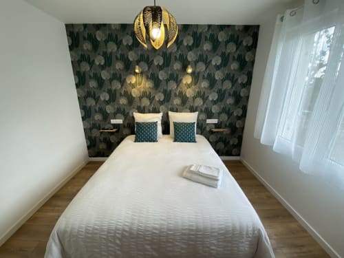 Chambre moderne à La Maison Blanche B&B à Bouguenais avec lit blanc, coussins bleu-vert et tête de lit à motifs floraux dorés