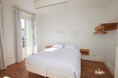 Bright Suite Juliette bedroom at Hidden Bay Hotel in Cayeux-sur-Mer with wooden floors, balcony access, and city views