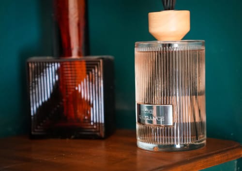 Flacons de parfum luxe avec bouchon en bois exposés sur table à l'hôtel Les séjours Ardennais à Renwez, France