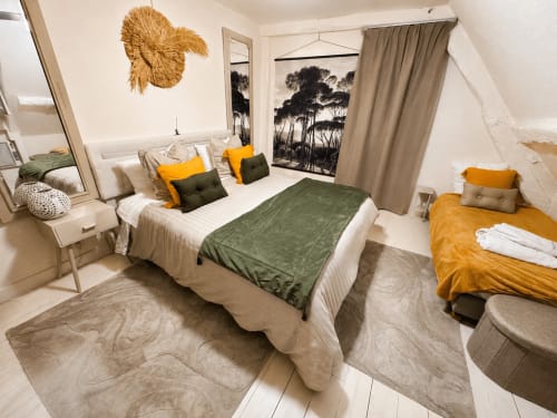 Chambre cosy au Domaine Valenquercy avec lit queen, touches de vert, coussins jaunes et décor moderne à Le Vignon-en-Quercy