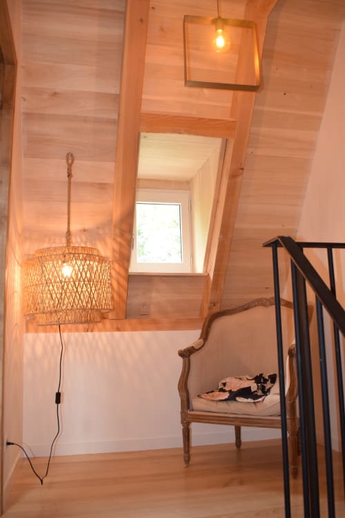 Chambre confortable en bois aux Pratges à Figeac avec lampe suspendue tissée et chaise rustique en bois
