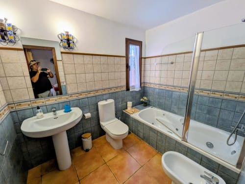 Baño espacioso en Villa Rodrigo en Sara & Gino Fuerteventura, Corralejo con lavabo, inodoro, bañera y paredes alicatadas