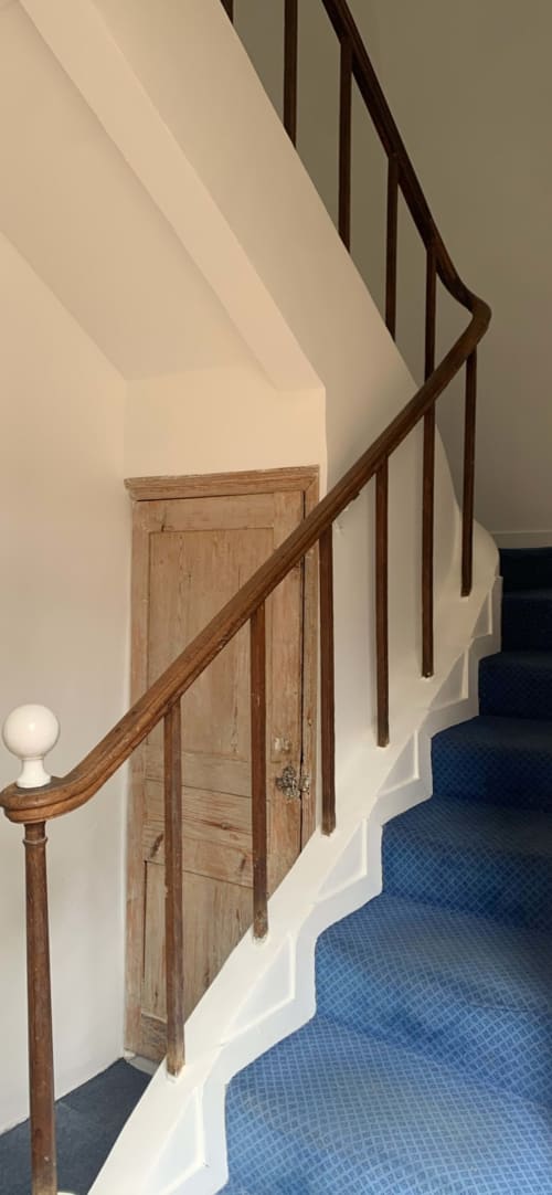 Escalier en bois, murs blancs et moquette bleue à l'appartement Le 58 Bayeux à Bayeux