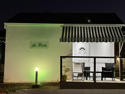Le gîte La Perle au Kaz A Bibi BnB à Sainte-Rose, Guadeloupe, illuminé la nuit avec son auvent rayé