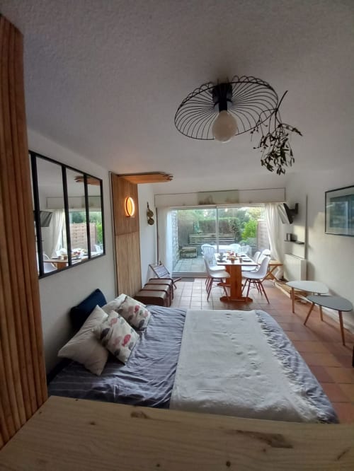 Chambre moderne à Mer et Maisons à La Trinité sur Mer avec vue sur jardin, lit, coin repas et accès à la terrasse