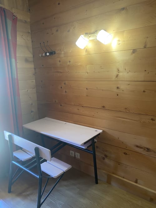 Espace de travail en cabane bois avec bureau, chaise et luminaires suspendus à La Ferme des Georgières, Notre-Dame-de-Bellecombe