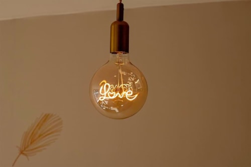 Luminaire mural 'Love' en néon brillant dans la chambre douillette des Gîtes Saint Valery En Caux, France