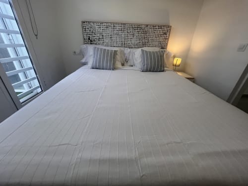 Modern bedroom with queen bed, striped pillows, and geometric headboard at FTV Holidays Homes in Corralejo