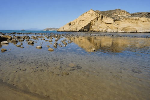 Rocky cove with sandy beach, turquoise water, and dramatic cliffs at Cuevas del Almanzora coastal apartment