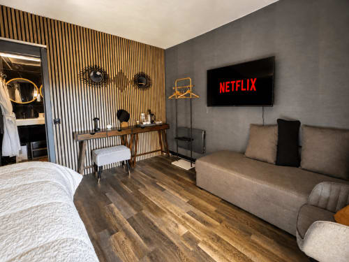 Suite moderne au Domaine Valenquercy avec lit, coin salon, TV Netflix, bureau en bois et équipements spa
