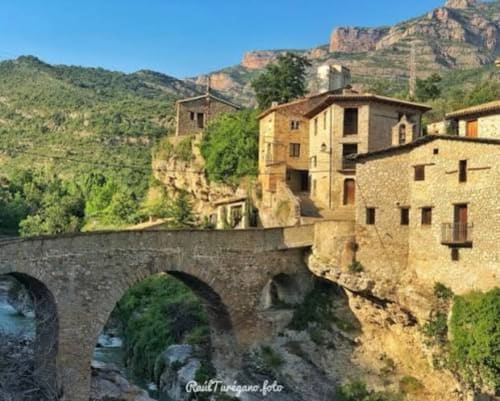 Puente medieval de piedra atravesando el río con arquitectura tradicional catalana en los Pirineos, Montgat