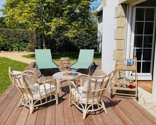 Terrasse ensoleillée de la villa Mer et Maisons avec transats, coin salon et terrasse en bois surplombant les jardins paysagers