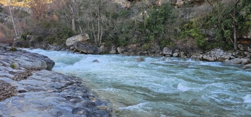Río turquesa fluyendo por valle boscoso en los Pirineos de Montgat, vistas montañosas desde el apartamento