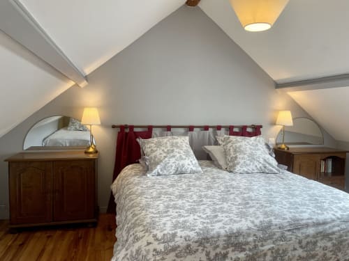 Chambre cosy du château de Vaux Morvan avec plafond cathédrale, lit queen, tête de lit bordeaux, tables de nuit assorties
