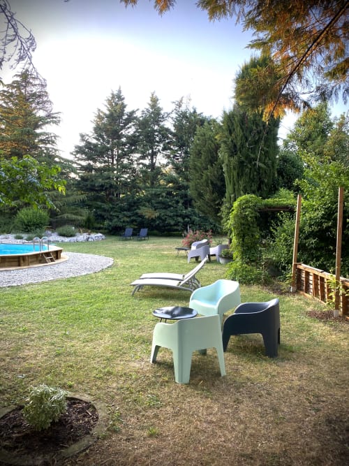 Grand jardin du gîte Le Cocon De Curson avec chaises longues, piscine et arbres luxuriants