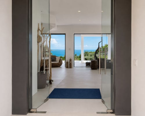 Modern villa entrance with sea view at Indigo Villa Samui, glass doors opening to terrace overlooking blue ocean