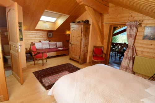 Chambre Art Pop à l'Auberge Nemoz avec poutres apparentes, lit queen-size, coin salon et terrasse avec vue sur les montagnes au Haut-Bréda