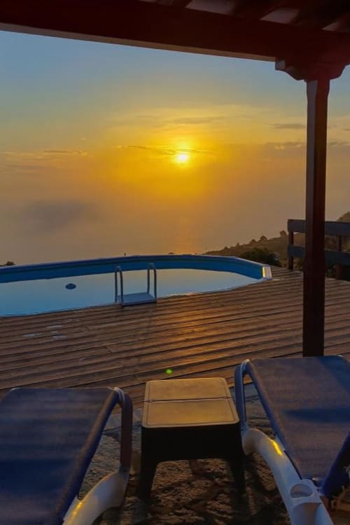 Vista del atardecer desde la terraza de Villa Las Flores con tumbonas, piscina y vistas al océano en Tijarafe, La Palma