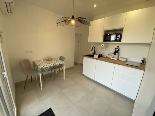 Cuisine-séjour contemporaine de l'Appartement 7 à La Maison Blanche, Bouguenais, avec mobilier blanc et table à manger