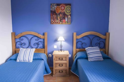 Camas gemelas con ropa de cama azul en Villa Rodrigo de Sara & Gino Fuerteventura, Corralejo, con marcos de madera y rayas