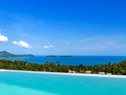 Indigo Villa Samui infinity pool overlooking tropical coconut palms and turquoise waters of Ko Samui, Thailand with sea view