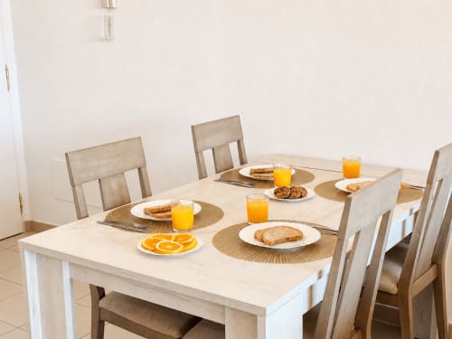 Mesa de desayuno con zumo de naranja, tostadas y naranjas frescas en Apartamentos El Calón Playa, Cuevas del Almanzora