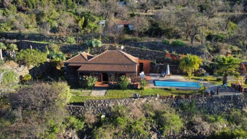 Villa El Topo vista aérea con tejado de terracota, piscina privada y jardines exuberantes en El Pinillo, La Palma