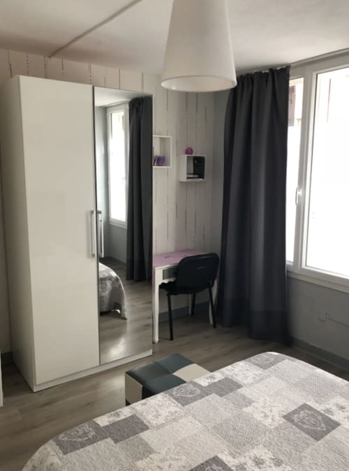 Chambre moderne avec penderie blanche, rideaux noirs et lit à l'appartement Le Paillot de Montabert à Troyes