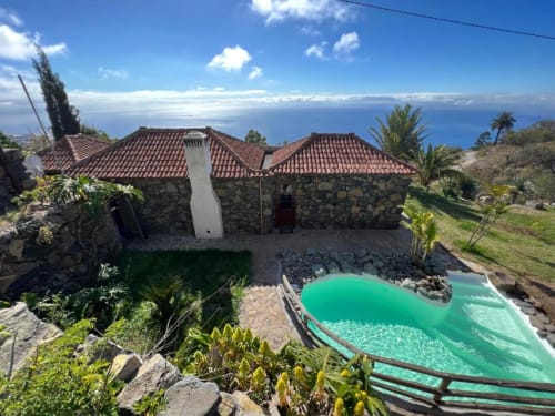 Villa Awara en El Pinillo, La Palma: Villa de piedra con piscina turquesa con vistas al océano y paisaje costero.