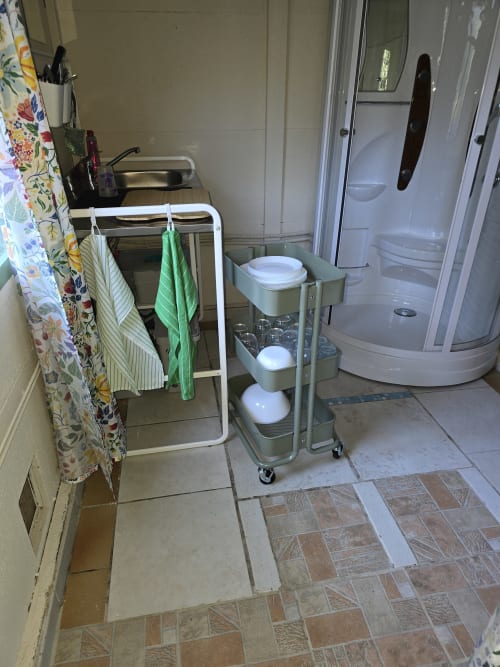 Salle de bains du cottage au Domaine Trianon avec douche, lavabo, porte-serviettes et rangements dans les jardins de Villandry