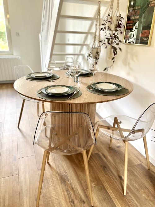 Table de salle à manger ronde élégante avec couverts et plantes suspendues au gîte Évasion voyage d'ART DE VOYAGER, Étretat