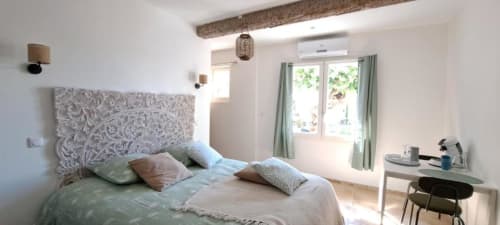 Suite lumineuse lit queen-size chez Laure & Marc B&B à Plaissan, vue jardin, tête de lit ornementale et équipements modernes